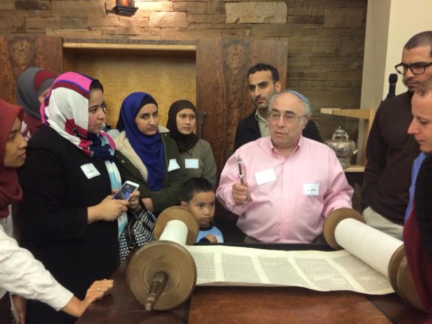 In the photo taken by Corinna Dranow, Anan Takroori is seen standing behind Rabbi Adler.